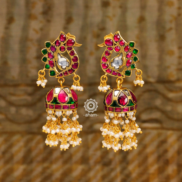 Introducing these Peacock Gold Polish Silver Jhumkie earrings - stunningly designed with a temple style inspired by ancient craftsmanship. Finely crafted with 92.5 sterling silver and a beautiful gold polish, they boast exquisite details that make them truly unique. The pearls add a gentle touch to the intricate design, making these earrings so light yet gorgeous.