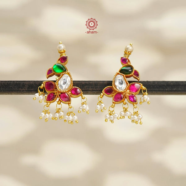 Cute little peacock earrings crafted in silver with kundan work and dipped in gold polish and laced with mini pearls. 