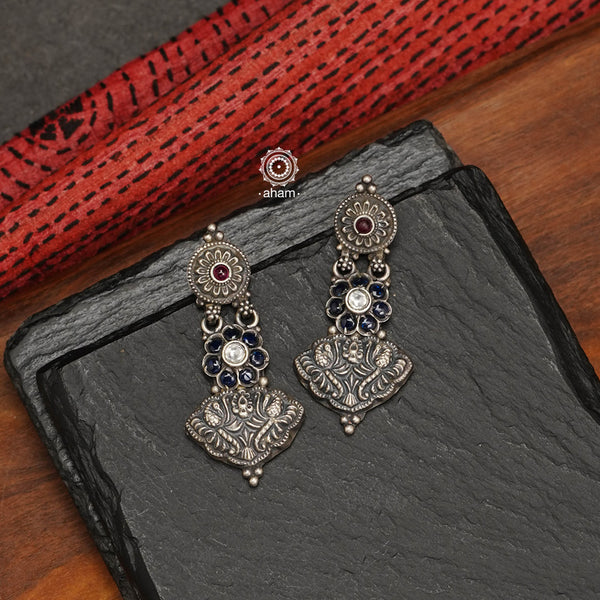 Earrings handcrafted in 92.5 sterling silver, with blue spinel stone highlights and nakshi work. 
