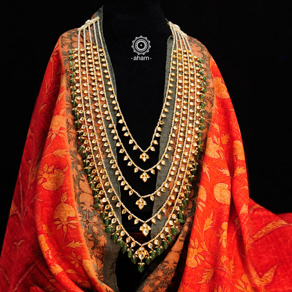 Our Five Line Kundan Gold Polish Silver Neckpiece, made with 92.5 silver and adorned with kundan and green drops, this rani haar exudes royal elegance. The gold polish adds a luxurious touch, making you look like a regal queen. Elevate any outfit with this exquisite piece.