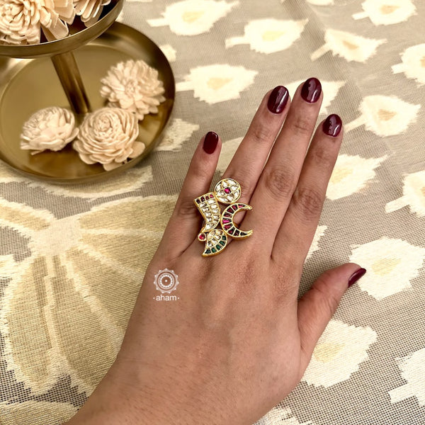This stunning silver ring showcases intricate kundan work and gold polish, featuring moon, tiger tooth, flower, and paisley symbols. Crafted with expert precision and attention to detail, this ring is a symbol of elegance and sophistication. Make a statement with this unique and timeless piece.