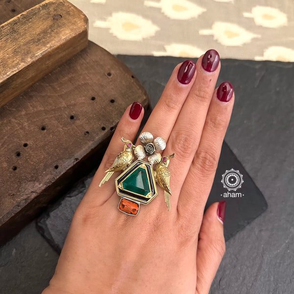 Noori two tone adjustable ring with peacock motif. Handcrafted in 92.5 sterling silver with green stone setting and a coral highlight. 