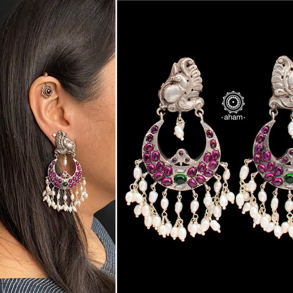 Handcrafted pair of Nrityam chandbali earrings in 92.5 sterling silver with Nakshi peacock stud, maroon kemp stone setting and hanging cultured pearls. 