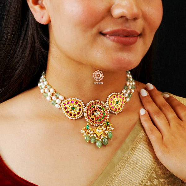 Make a sophisticated style statement with this gold polish festive choker with an elegant swan motif center. Handcrafted in 92.5 sterling silver with red and rani pink kundan work, green semi precious beads and cultured pearls. Perfect for intimate weddings and upcoming festive celebrations.  