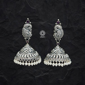 Elegant Nakshi peacock jhumkie earrings with intricate work. Handcrafted by skillful artisans in 92.5 sterling silver, with maroon kemp highlights and cultured pearls.