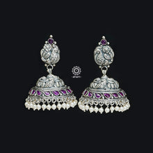 Elegant Nakshi peacock jhumkie earrings with intricate work. Handcrafted by skillful artisans in 92.5 sterling silver, with maroon kemp stone and cultured pearls.