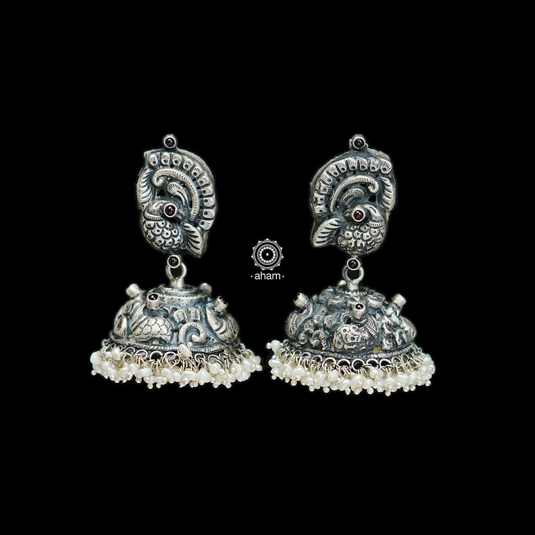 Elegant Nakshi peacock jhumkie earrings with intricate work. Handcrafted by skillful artisans in 92.5 sterling silver, with maroon kemp stone and cultured pearls.