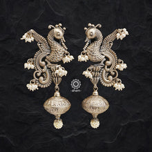 A handmade, one of a kind earring with complex peacock detailing. Crafted with precision by expert artisans, this piece features delicate pearl details for an intricate look. Perfect for an elegant statement.