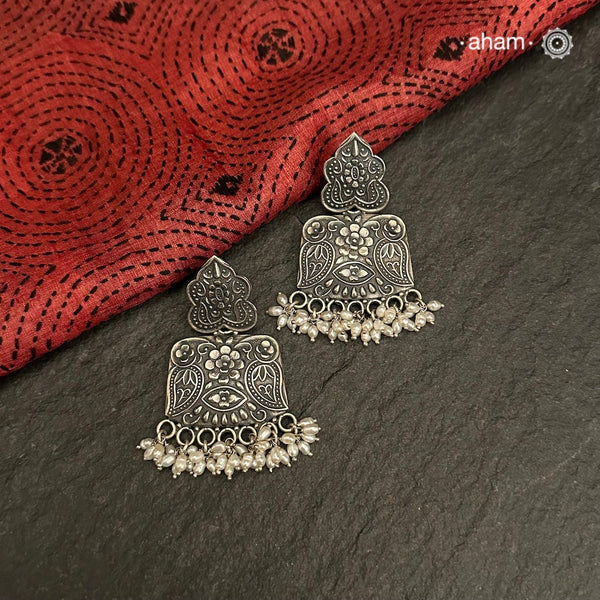Mewad earrings with intricate floral work and cultured pearls. Handcrafted in 92.5 sterling silver. An ode to the glorious state of Rajasthan. 