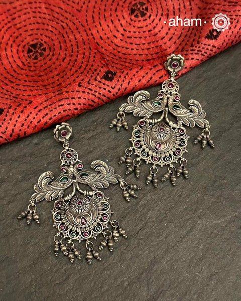 Expertly crafted, the Mewad Double Peacock Silver Earrings make a stunning statement. With oversized design, greenstone highlights and perfect craftsmanship, these earrings are perfect to elevate your traditional look.