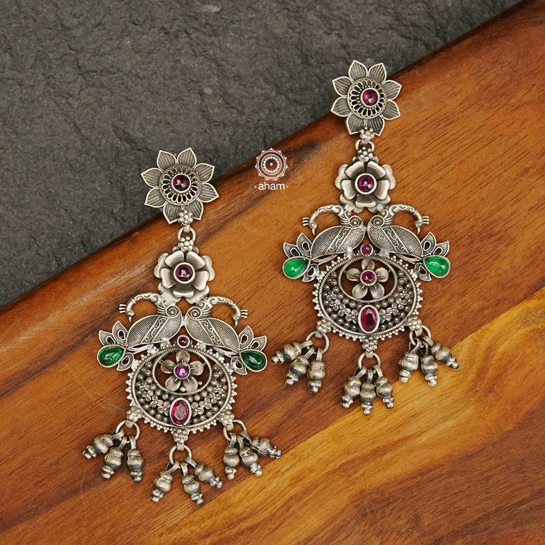 Mewad double peacock earrings handcrafted in 92.5 sterling silver with green and maroon stones. An ode to the glorious state of Rajasthan. Perfect pair of elegant danglers for your ethnic outfits. 