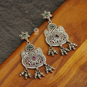 Mewad flower drop earrings with rani pink coloured stone highlights. Handcrafted in 92.5 sterling silver with intricate work and statement ghungroos. An ode to the glorious state of Rajasthan. 