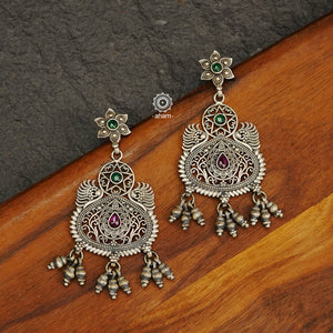 Mewad flower drop earrings with rani pink coloured stone highlights. Handcrafted in 92.5 sterling silver with intricate work and statement ghungroos. An ode to the glorious state of Rajasthan. 