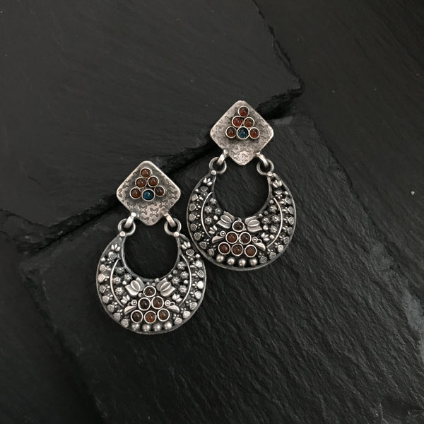 Complete your wardrobe with the elegance of these Double Sided Silver Earrings. Featuring maroon and deep blue stones, crafted in silver, they can easily be switched up to match your mood for the day. Perfect for any occasion.