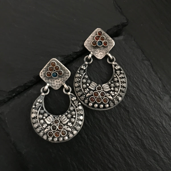 Complete your wardrobe with the elegance of these Double Sided Silver Earrings. Featuring maroon and deep blue stones, crafted in silver, they can easily be switched up to match your mood for the day. Perfect for any occasion.