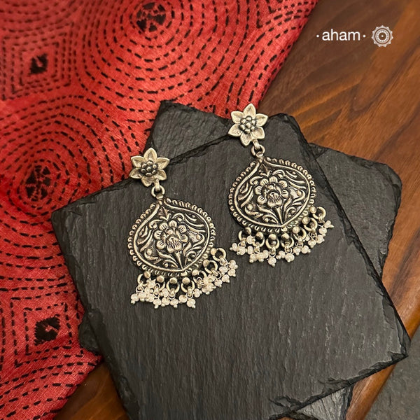 Crafted in 92.5 silver, these Mewad earrings feature intricate floral patterns and are laced with pearls. The perfect accessory for adding a touch of elegance and sophistication to any outfit.