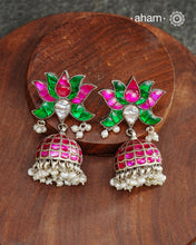 Handcrafted in 92.5 sterling silver with dangling cultured pearls, rani (pink) and kundan work.These festive lotus jhumkie earrings will add more bling and drama to your jewellery collection.