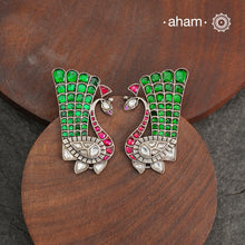 These festive peacock silver earrings are expertly crafted in 92.5 silver, with exquisite green and pink kundan detailing. Elevate any look with these stunning earrings that are sure to make a statement.