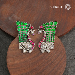 These festive peacock silver earrings are expertly crafted in 92.5 silver, with exquisite green and pink kundan detailing. Elevate any look with these stunning earrings that are sure to make a statement.