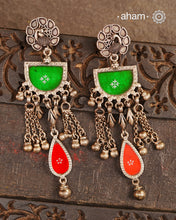 Expertly crafted from 92.5 sterling silver, these Rang Mahal earrings feature a vibrant blend of green and red hues. With a peacock stud design, they effortlessly combine glass and silver to create a stunning pop of color. Make a bold statement with these beautiful, handcrafted earrings that are sure to become a favorite in your collection.