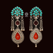 Add a touch of oomph to your outfit with our Turquoise & Crimson Rang Mahal Silver Earrings. Handcrafted in 92,5 silver, these statement earrings feature a bold turquoise top and a dazzling crimson red glass drop. Elevate your style with these stunning earrings.