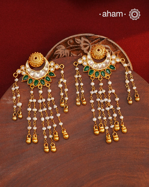 Handcrafted gold polish kundan chand earrings with dangling cultured pearls. Crafted using&nbsp;traditional techniques in 92.5 sterling silver with&nbsp;green stone highlights. Perfect for&nbsp;special occasions&nbsp;and upcoming festive celebrations.