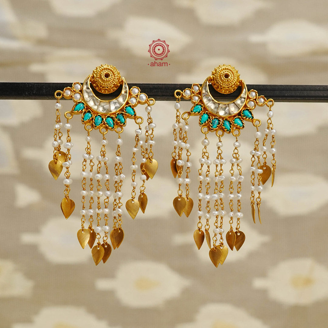 Handcrafted gold polish kundan crescent earrings. Crafted using traditional techniques in 92.5 sterling silver with dangling cultured pearls and turquoise coloured drops. Beautiful chandelier earrings for special occasions and upcoming festive celebrations.