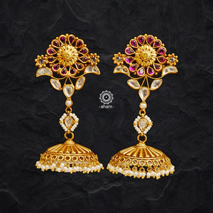 Experience a unique styling with these Gold Polish Silver Kemp Flower Jhumkies. Crafted in 92.5 silver with gold polish and kundan setting, each pair is adorned with delicate pearls, giving it a regal look. Perfect for any occasion.