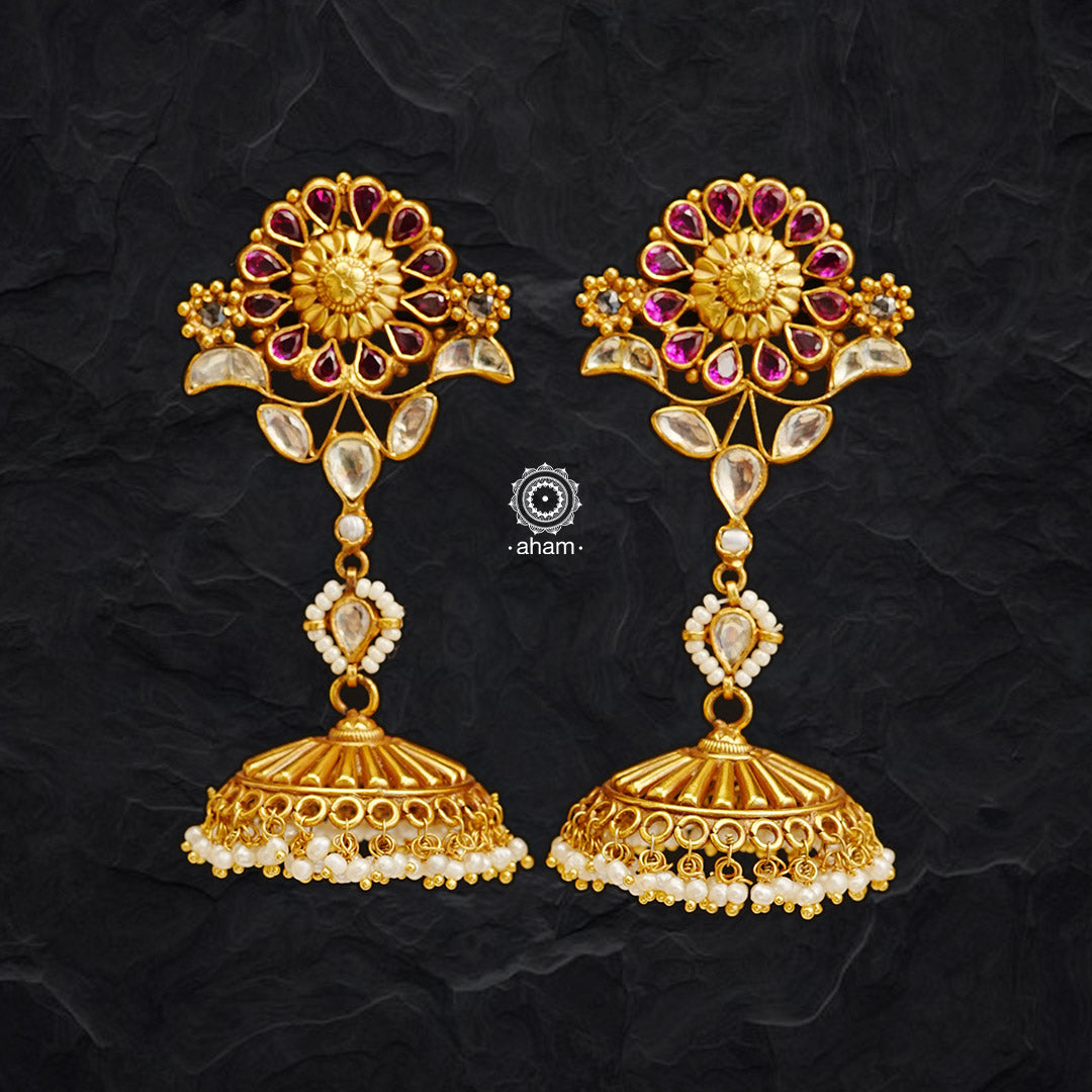 Experience a unique styling with these Gold Polish Silver Kemp Flower Jhumkies. Crafted in 92.5 silver with gold polish and kundan setting, each pair is adorned with delicate pearls, giving it a regal look. Perfect for any occasion.