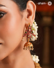 Festive gold polish jhumkie earrings with rani pink kundan work. Handcrafted using traditional methods in silver with double peacock motif and dangling cultured pearls. Style these up with your favourite ethnic outfits to dazzle up your festive looks.