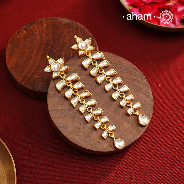 These long shoulder duster earrings feature an elegant cascading design, expertly crafted in 92.5% silver with a refined gold polish. The intricate kundan setting adds a traditional touch, making them an exquisite choice for festive occasions and parties. Their lightweight construction ensures comfortable wear while making a striking statement. Perfect for elevating your evening attire with a blend of classic craftsmanship and contemporary style.