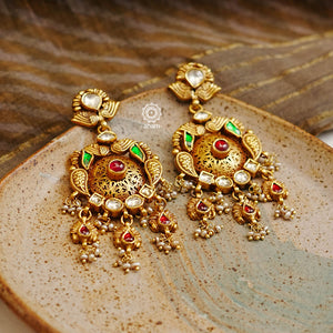 Add a touch of elegance to any outfit with these traditional chandelier-style Kundan gold polish silver earrings. Crafted with 92.5 silver and finished with gold polish, Kundan and pearl highlights, they are the perfect piece to go with any festive occasion.