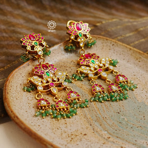 Statement gold polish chandelier earrings with elegant peacock motif. Handcrafted using traditional techniques in silver with kundan work and dangling cultured pearls. Perfect for intimate weddings and upcoming festive celebrations.