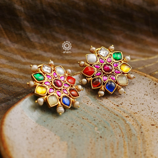 These Navratna Gold Polish Silver Studs are the perfect accessory for any special occasion. Crafted in silver with a gold polish, these earrings feature a classic Kundan setting for a timeless look that will shine forever. Add a touch of elegance to your wardrobe with these must-have studs.