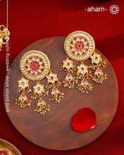 Statement gold polish earring with multiple mini dangling flowers. Handcrafted using traditional methods in 92.5 sterling silver with cultured pearls. Pair these with your ethnic outfits this festive season to ace your look.