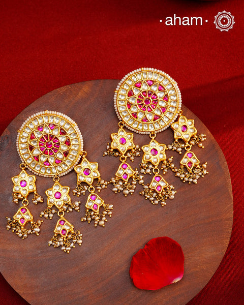Statement gold polish earring with multiple mini dangling flowers. Handcrafted using traditional methods in 92.5 sterling silver with cultured pearls. Pair these with your ethnic outfits this festive season to ace your look.