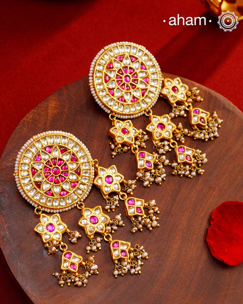 Statement gold polish earring with multiple mini dangling flowers. Handcrafted using traditional methods in 92.5 sterling silver with cultured pearls. Pair these with your ethnic outfits this festive season to ace your look.