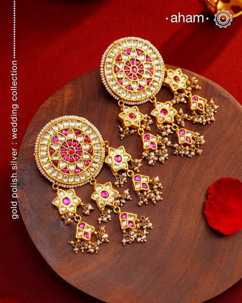 Statement gold polish earring with multiple mini dangling flowers. Handcrafted using traditional methods in 92.5 sterling silver with cultured pearls. Pair these with your ethnic outfits this festive season to ace your look.