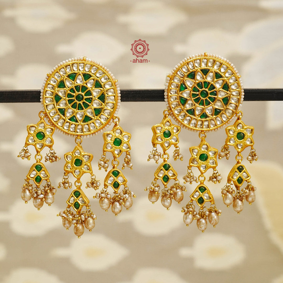 Elevate your style with our Festive Green Kundan Gold Polish Silver Earrings. These magnificent statement earrings feature detailed kundan work and delicate pearls, all crafted in 92.5 silver. These showstopper earrings are all you need for your next big occasion.