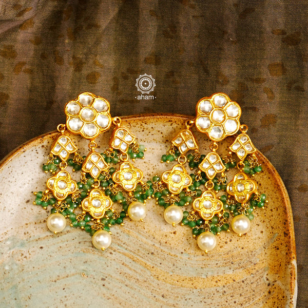 Statement gold polish earring with multiple mini dangling flowers. Handcrafted using traditional methods in 92.5 sterling silver with cultured pearls. Pair these with your ethnic outfits this festive season to ace your look.