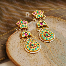 Statement gold polish chandelier earrings with elegant peacock motif. Handcrafted using traditional techniques in silver with kundan work and dangling cultured pearls. Perfect for intimate weddings and upcoming festive celebrations.