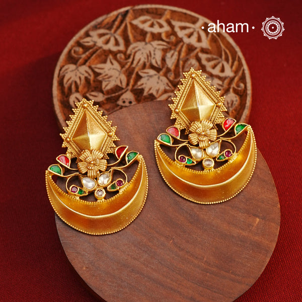 Classic diya earrings handcrafted from 92.5 sterling silver and adorned with kundan and rava work. The subtle dull gold polish adds a touch of elegance and beauty, making these the perfect accessory for any special occasion.