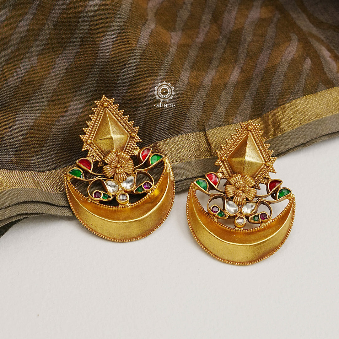 Classic diya earrings handcrafted from 92.5 sterling silver and adorned with kundan and rava work. The subtle dull gold polish adds a touch of elegance and beauty, making these the perfect accessory for any special occasion.