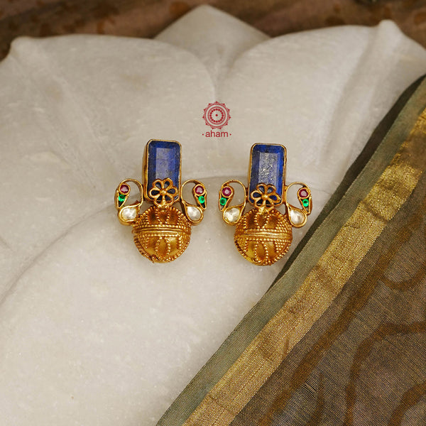So many details packed in these little earrings. Beautiful rava work drop complimented with peacocks on two sides and a stunning stone highlight in the center. Crafted in silver with gold polish. 
