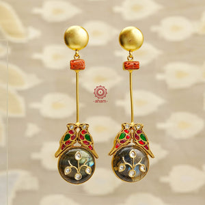 Looking for statement yet minimal earrings? Look no further! Skillfully crafted in 92.5 silver and dipped in 24k gold, these earrings feature two beautifully perched birds over a semi precious stone with inlay work. The hint of natural coral adds a unique touch. Elevate your style with these stunning earrings.