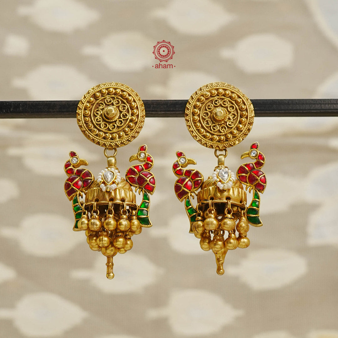 Elevate your style with our Peacock Gold Polish Silver Jhumkas. Crafted with stunning kundan peacocks, these statement earrings are the perfect accessory to elevate any outfit. The gold polish adds a touch of elegance, making them a versatile match for most ensembles.