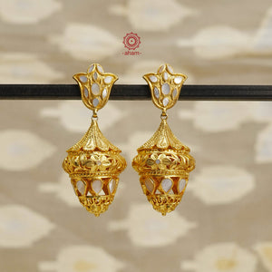 Step into the timeless elegance of our Mother of Pearl Gold Polish Silver Jhumkie. This Victorian-inspired chandelier design features lustrous gold polish and a stunning mother of pearl accent. Exquisitely crafted in silver, this is a must-have for any jewelry collection. Elevate your look with this exquisite piece.