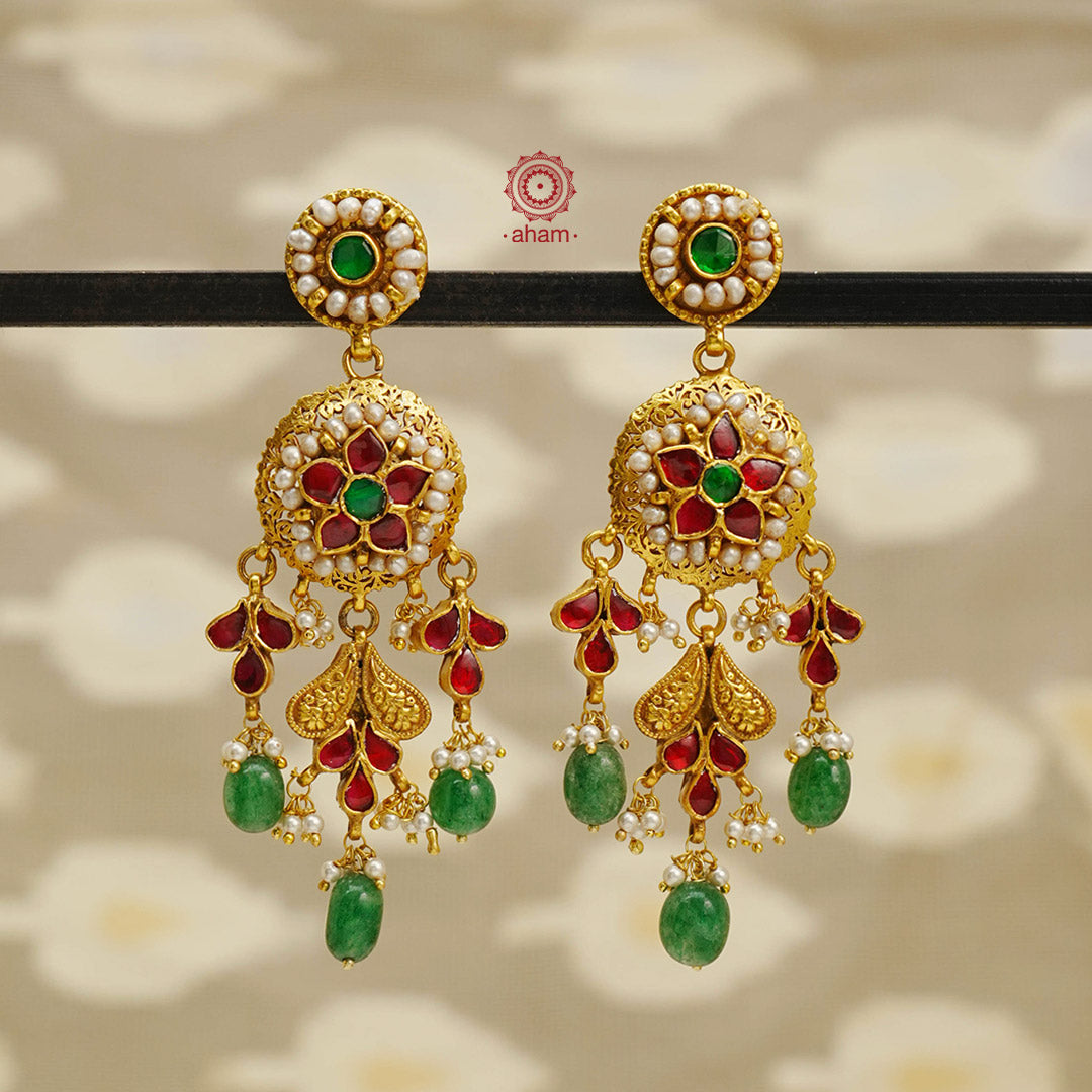 Experience traditional elegance with our Kundan Gold Polish Silver Earrings. The delicate kundan and pearl work, combined with a beautiful green drop, adds a touch of sophistication to any outfit. With this exquisite design, you will be sure to make a statement at any event.