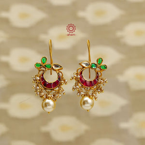 Elegant gold polish earrings embellished with kundan work and a pearl drop. Handcrafted in 92.5 sterling silver. Perfect for special occasions and festivities.