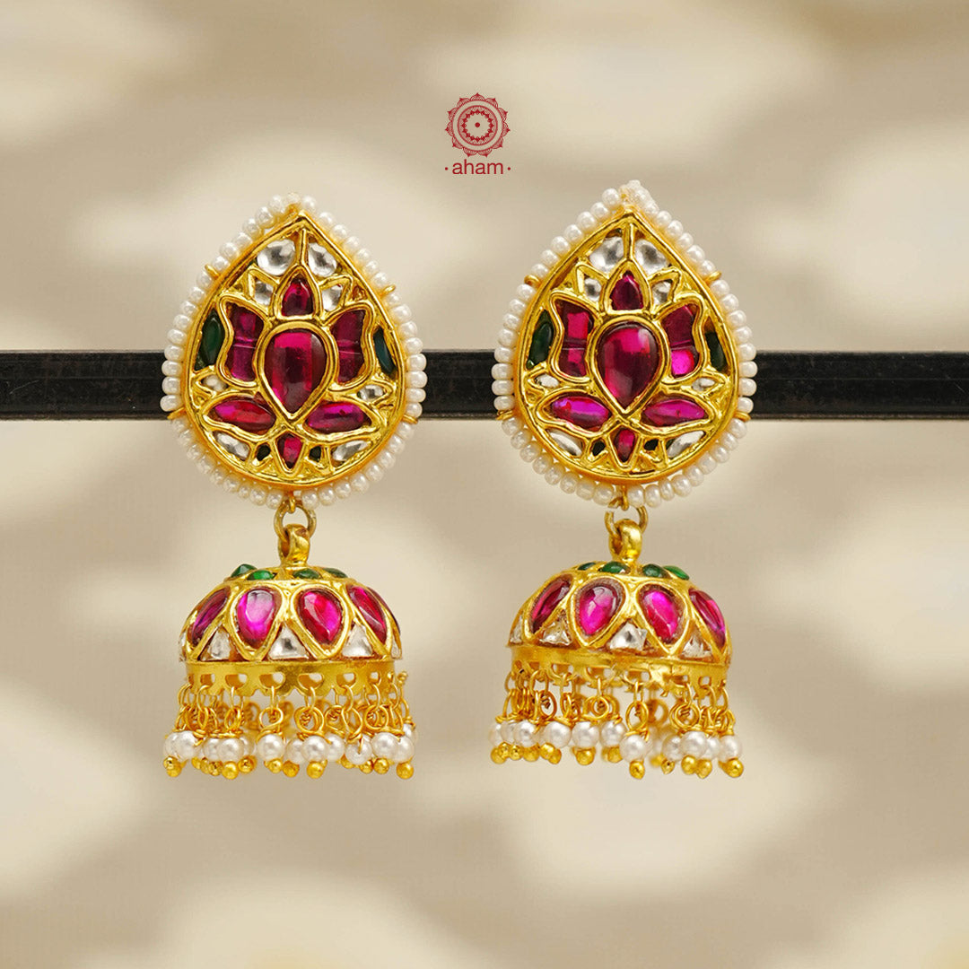 Festive gold polish jhumkie earrings with intricate floral work. Handcrafted in 92.5 sterling silver with kundan highlights and dangling cultured pearls. Style these up with your favourite ethnic outfits to dazzle up your festive looks.